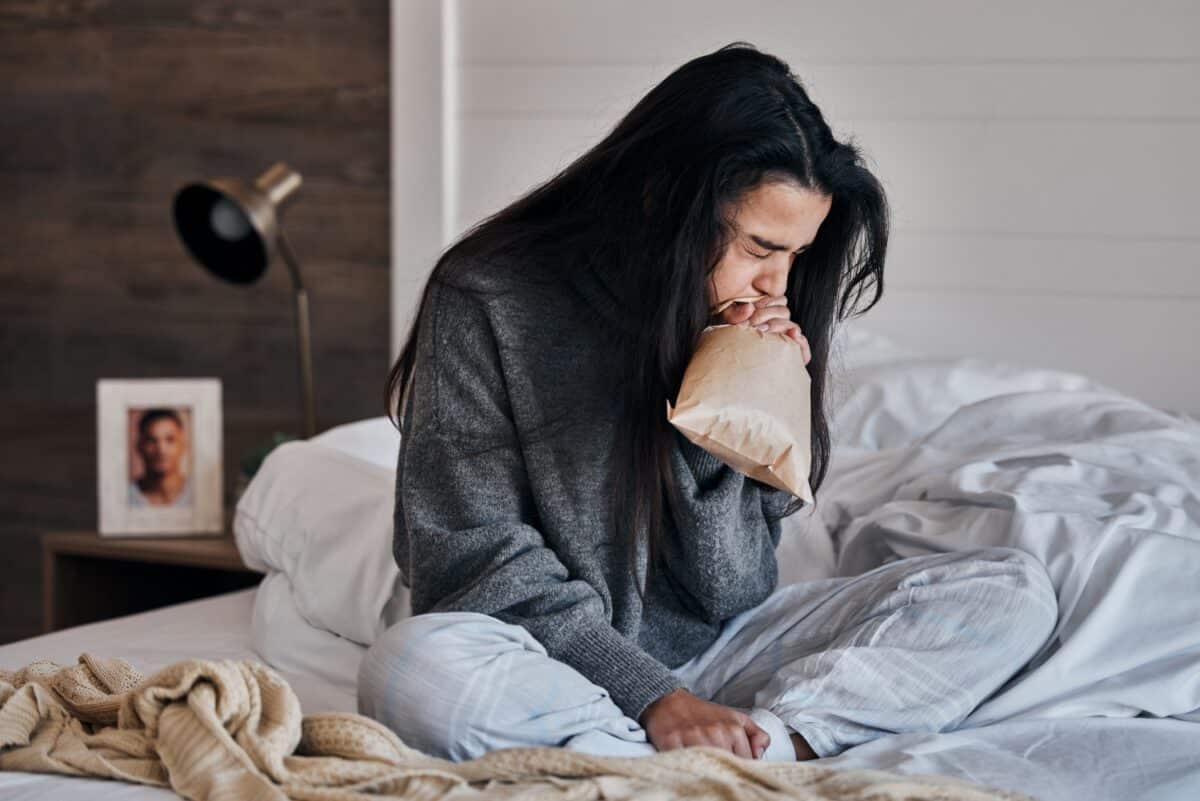 Vrouw, angst en papieren zak stress ademhaling op bed in huis of slaapkamer