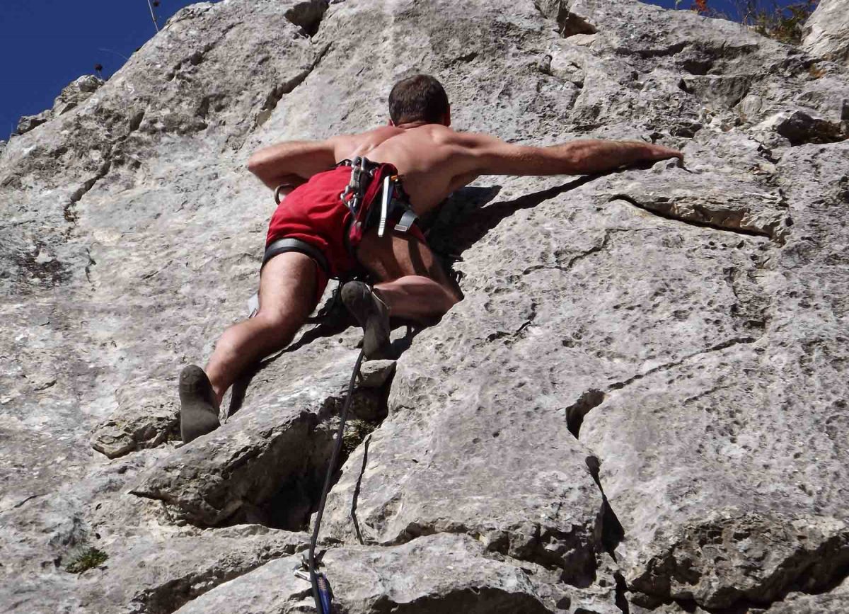 Client experiencing the thrill of rock climbing as part of White River Manor’s adventure activities in South Africa, with a scenic landscape in the background, promoting adrenaline-fueled wellness experiences.
