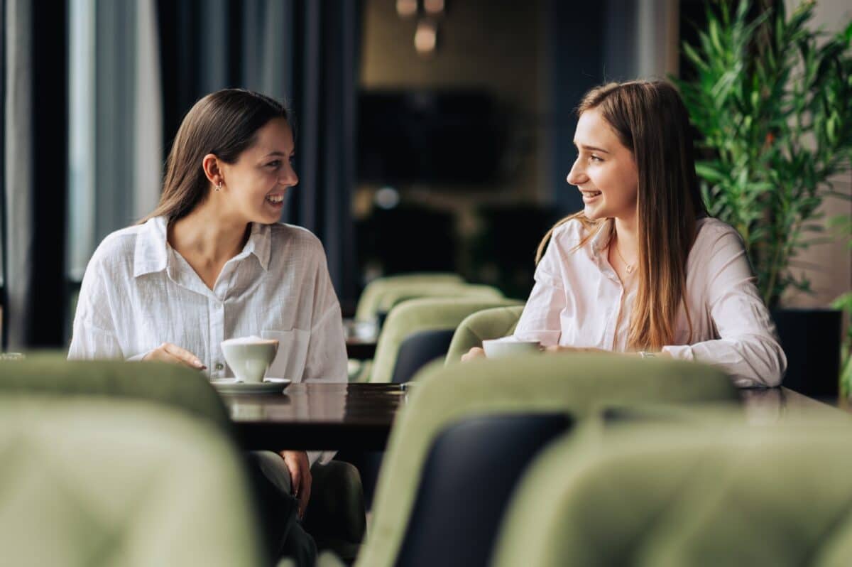 Twee dames zitten in een café, concept van de relatie tussen sponsor en gesponsorde van een verslavingshersteller