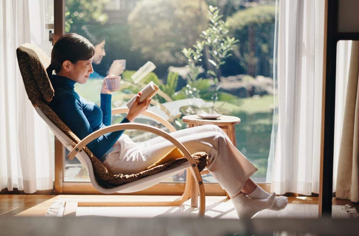 vrouw die een boek leest terwijl ze koffie drinkt, concept van ontkoppeling en ontspanning