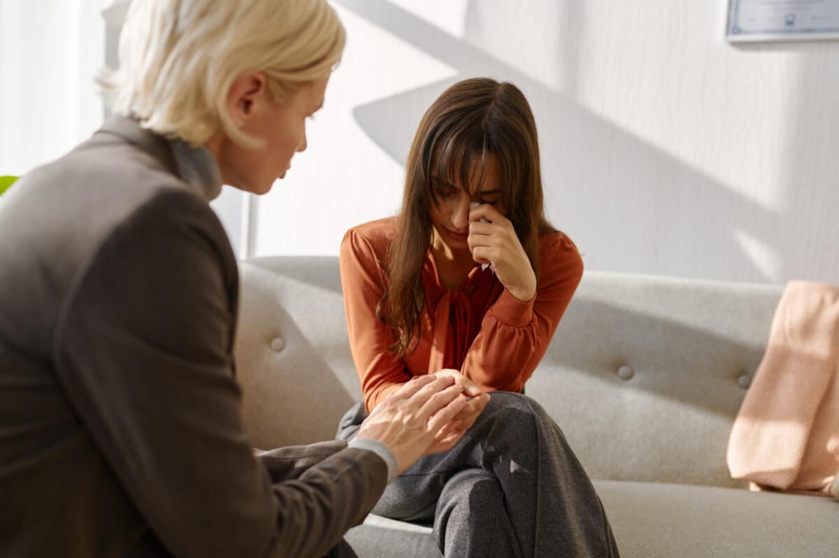 Emotional young woman patient talking to psychologist