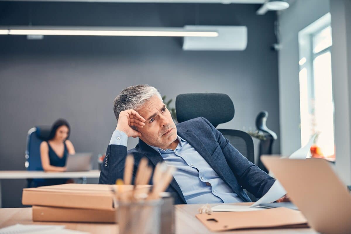 Overworked businessman frustrated and stressed in his office, concept of burnout