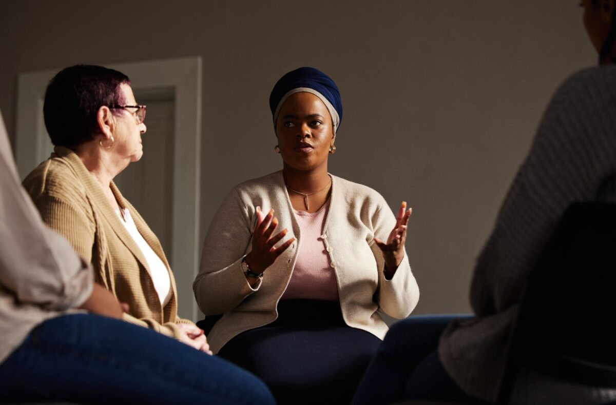Support, black woman and senior group therapy with understanding, feelings and talking in session