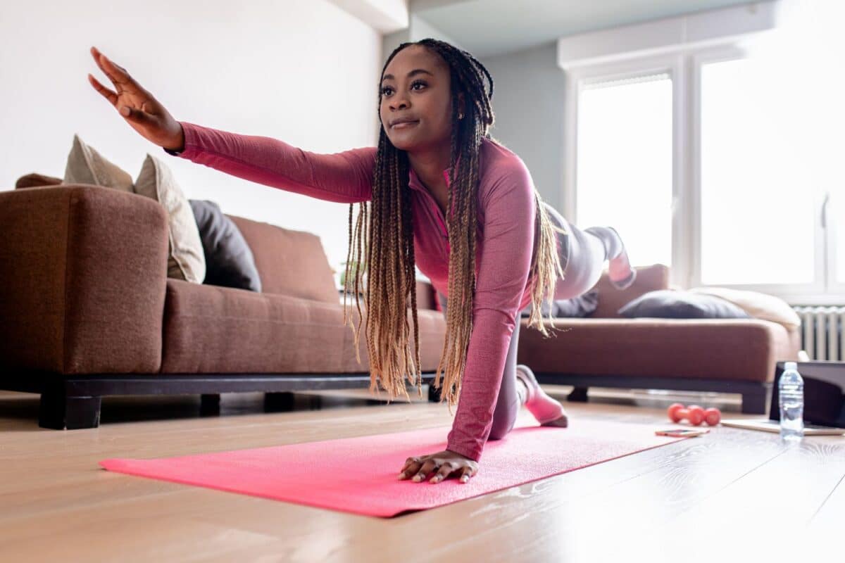 Young african american woman at home doing exercise.