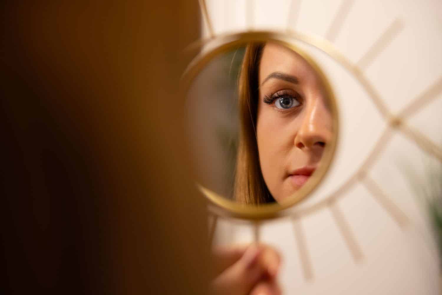 Young Woman Looking At Her Reflection