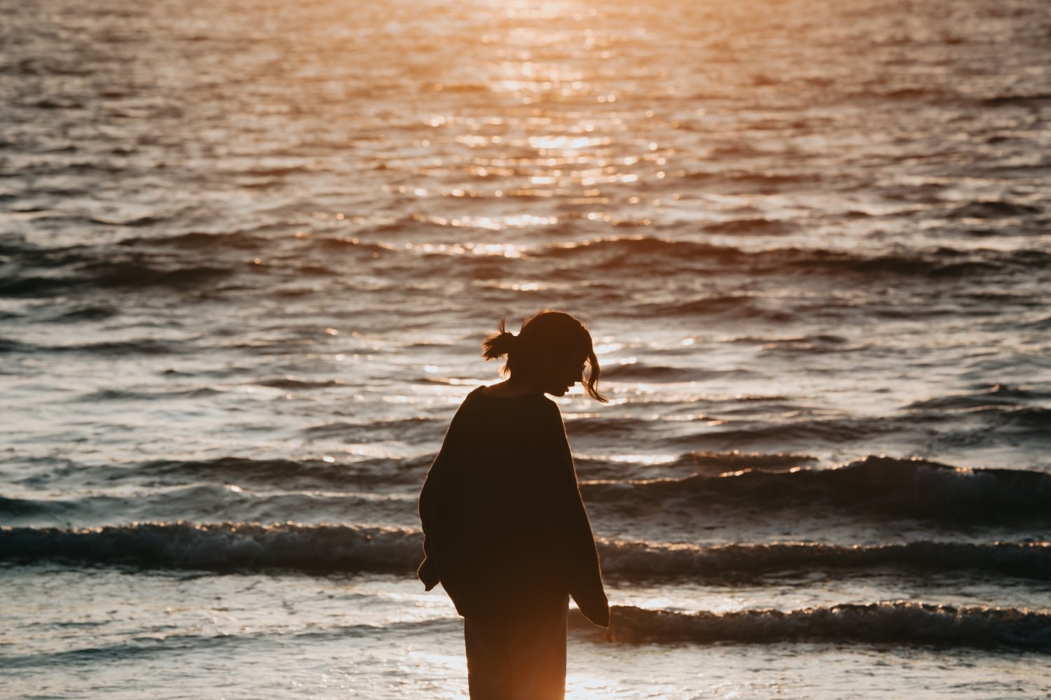 Young woman at the beach during a sunset