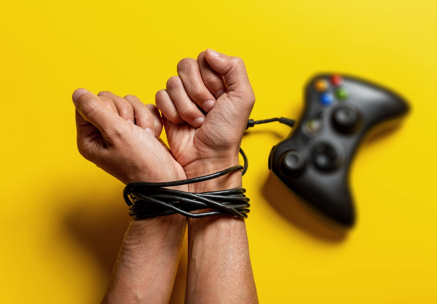 hands tied with gaming controller cable