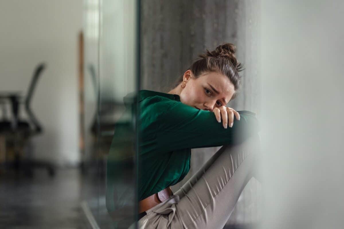 image of a sad, traumarised woman sitting alone, concept of trauma and mental health