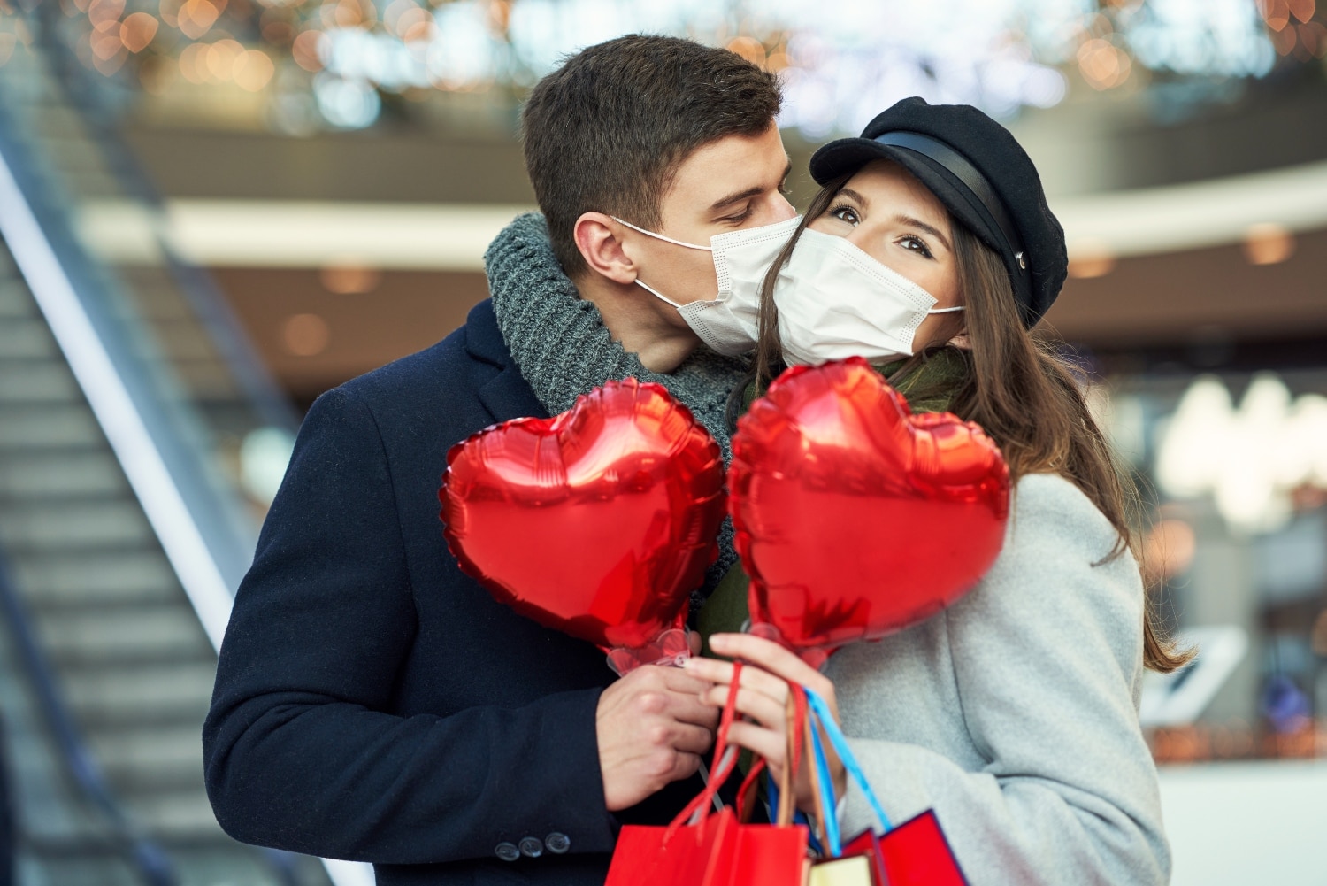 kissing couple holding heart balloons