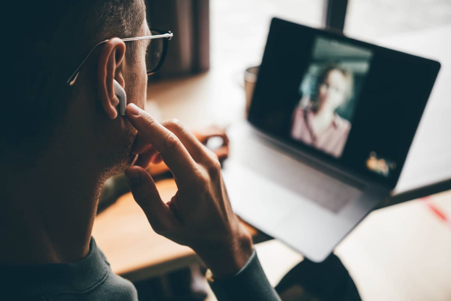 man puts on earphones to join video chat