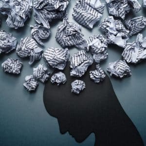 Silhouette of depressed person head. Concept image of depression and anxiety. Waste paper and head silhouette.