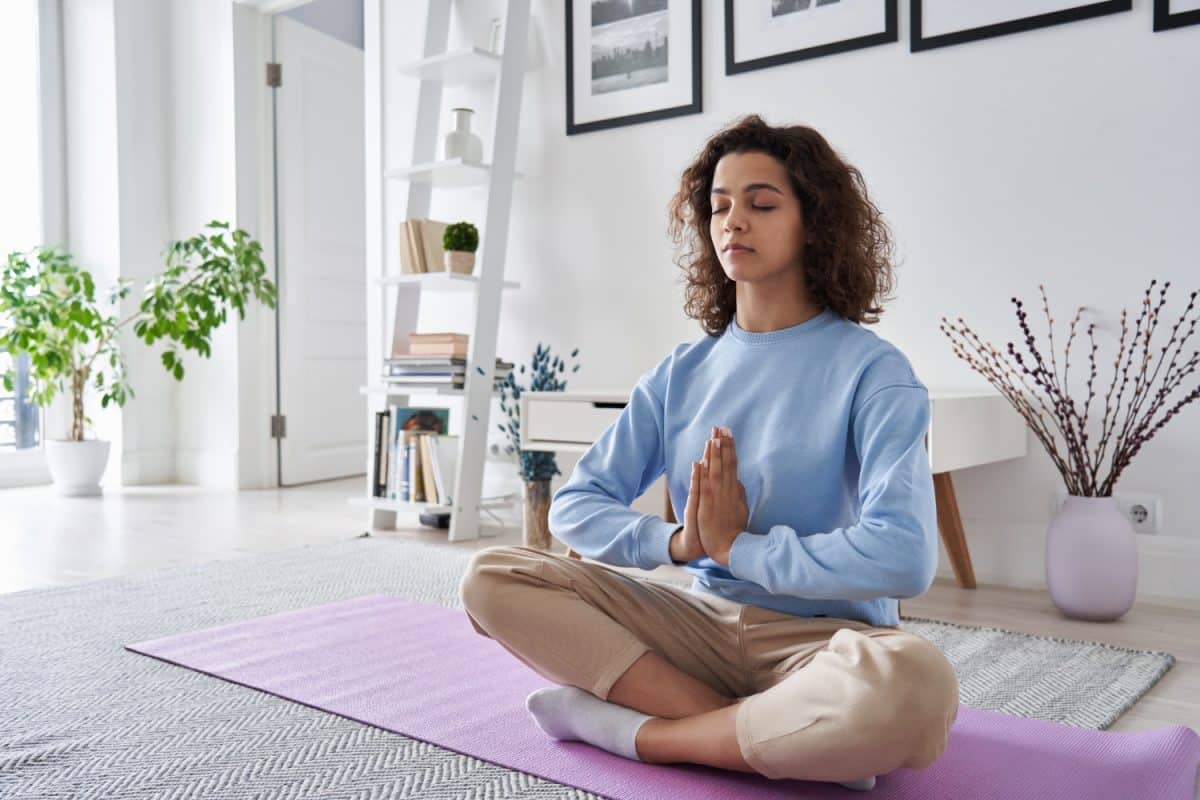 woman in blue sweater doing meditation