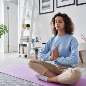 woman in blue sweater doing meditation