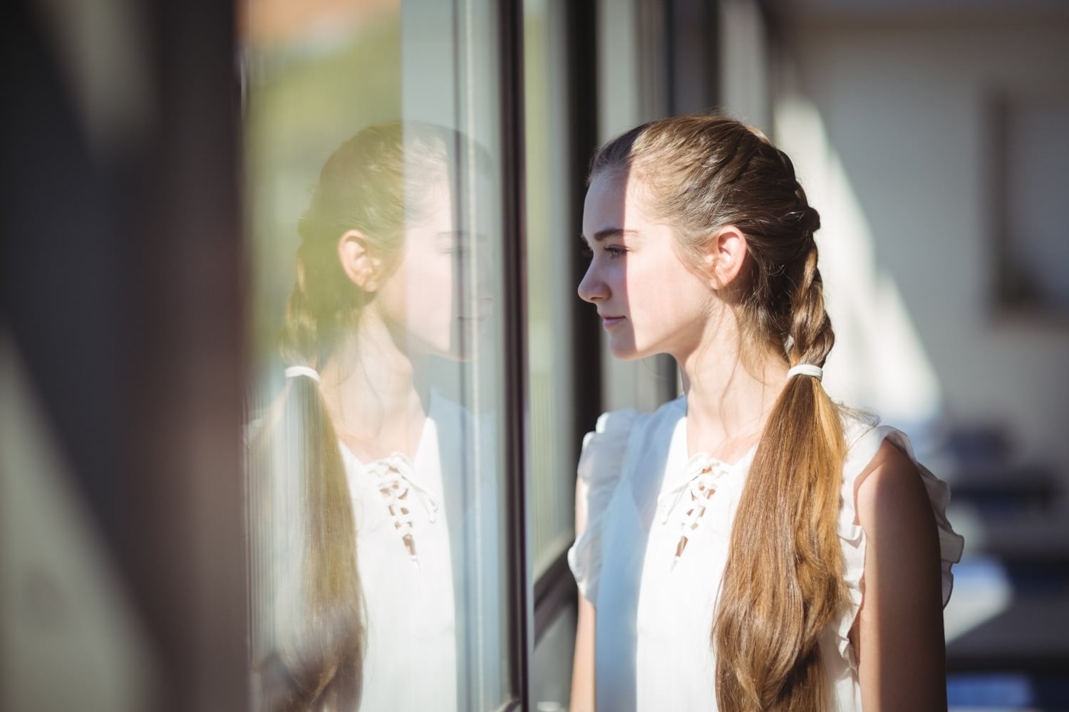 woman standing by the window, looking ahead, concept of self reflection