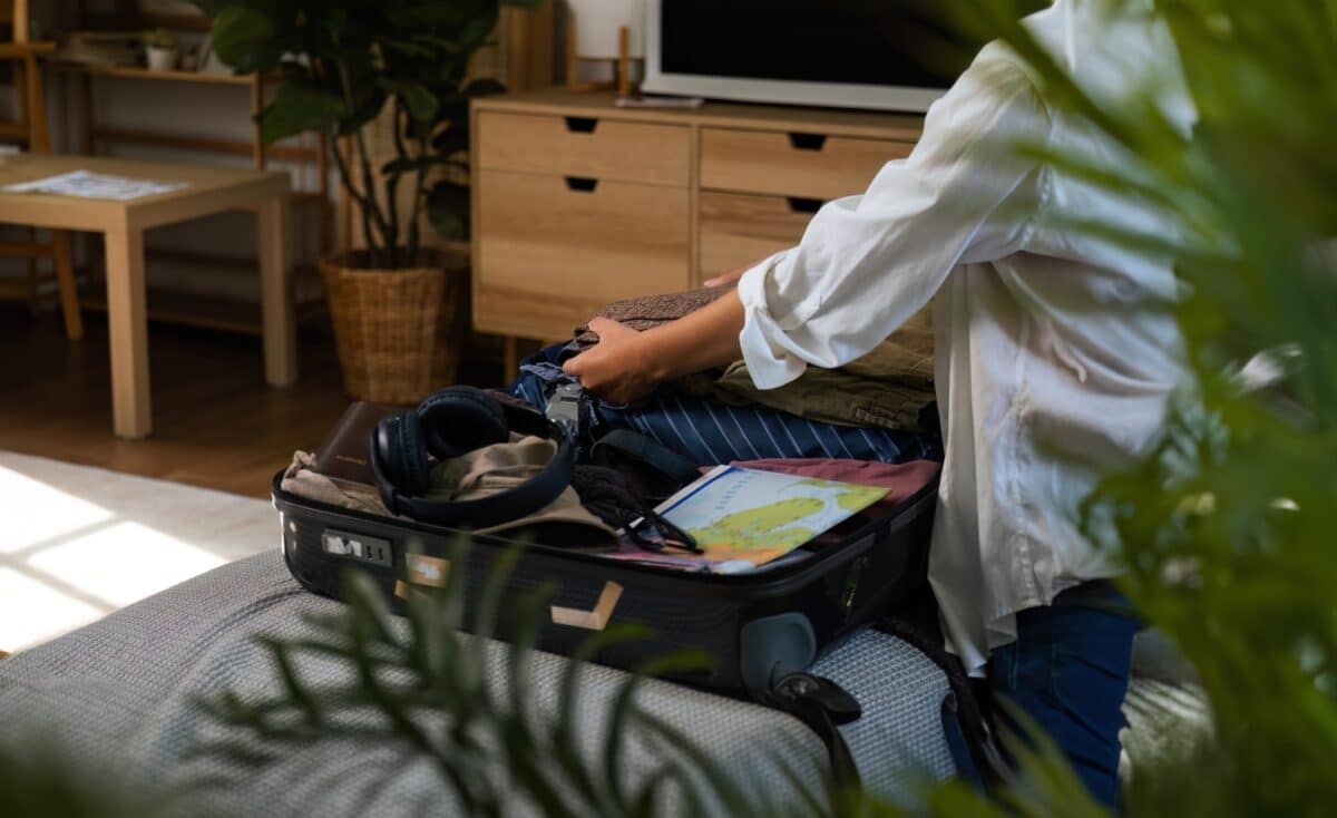 young woman preparing and packing clothes and luggage for traveling to rehab