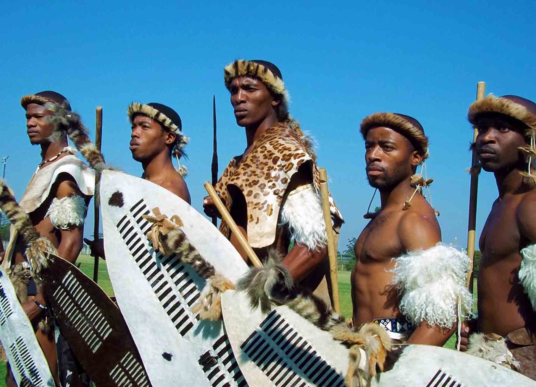 Traditional Zulu dancers performing in colorful attire, showcasing South African cultural heritage as part of the experiences offered at White River Manor